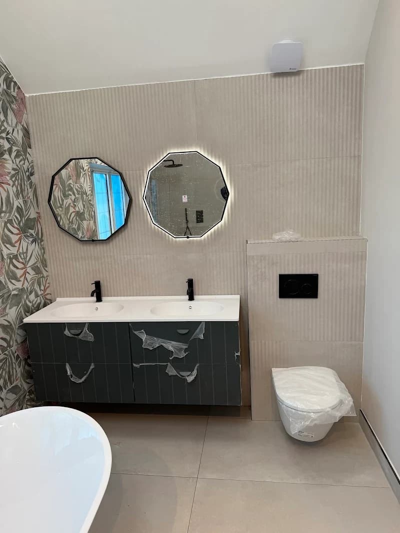 Bathroom with round mirror, vanity, and floor-to-ceiling tiling
