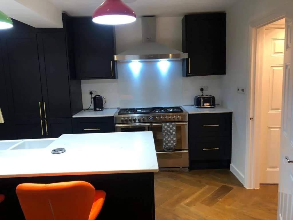 Kitchen with dark cabinetry and feature pendant lighting
