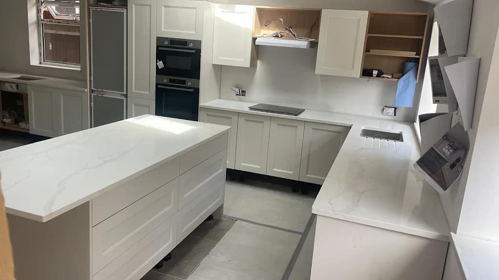 White kitchen with island unit and marble worktop